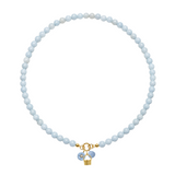 Necklace with light blue beads and a gold charm on a white background