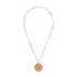 gold scalloped charm with blue gemstones on an aquamarine stone strand of beads