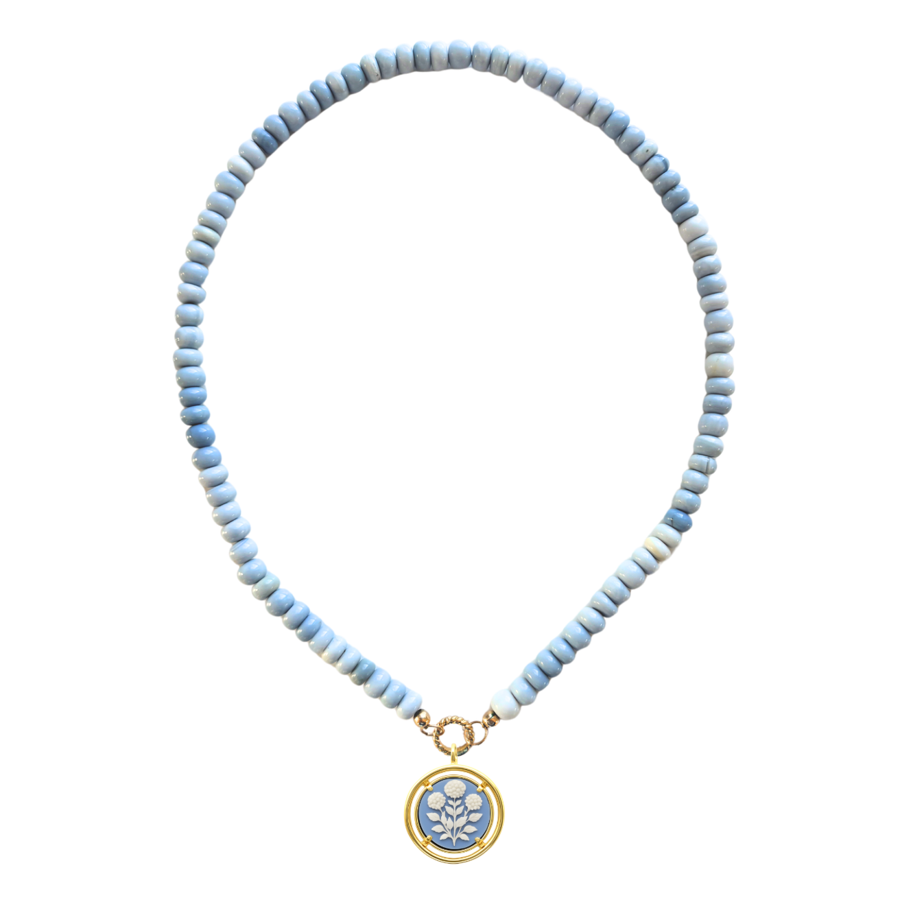 Necklace with light blue beads and a gold and blue cameo pendant on a white background