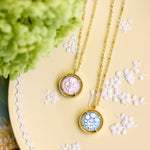 two cameo necklaces displayed on a light yellow plate