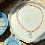 Necklace with heart-shaped pendants on a decorative dish with a woven background