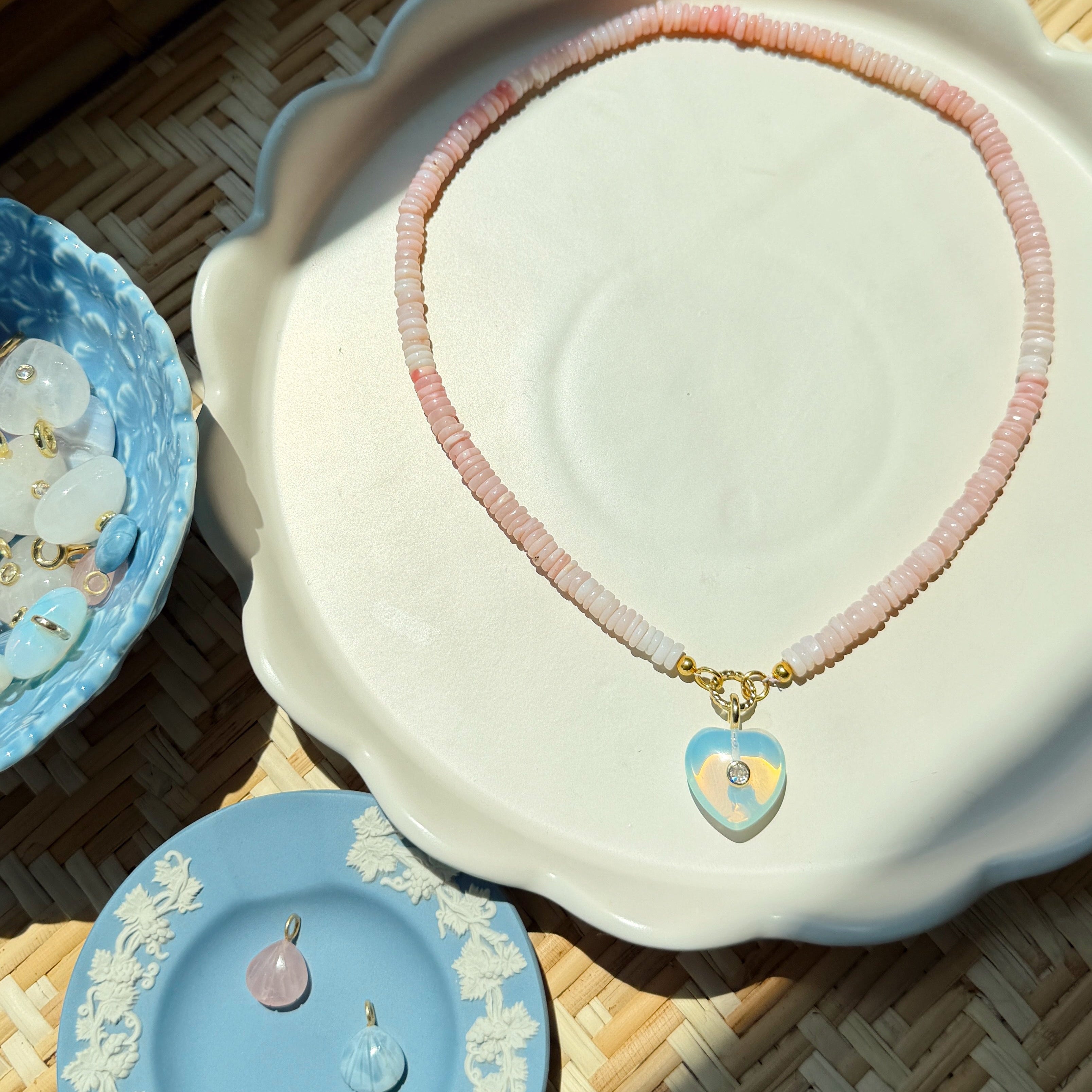 Necklace with heart-shaped pendants on a decorative dish with a woven background