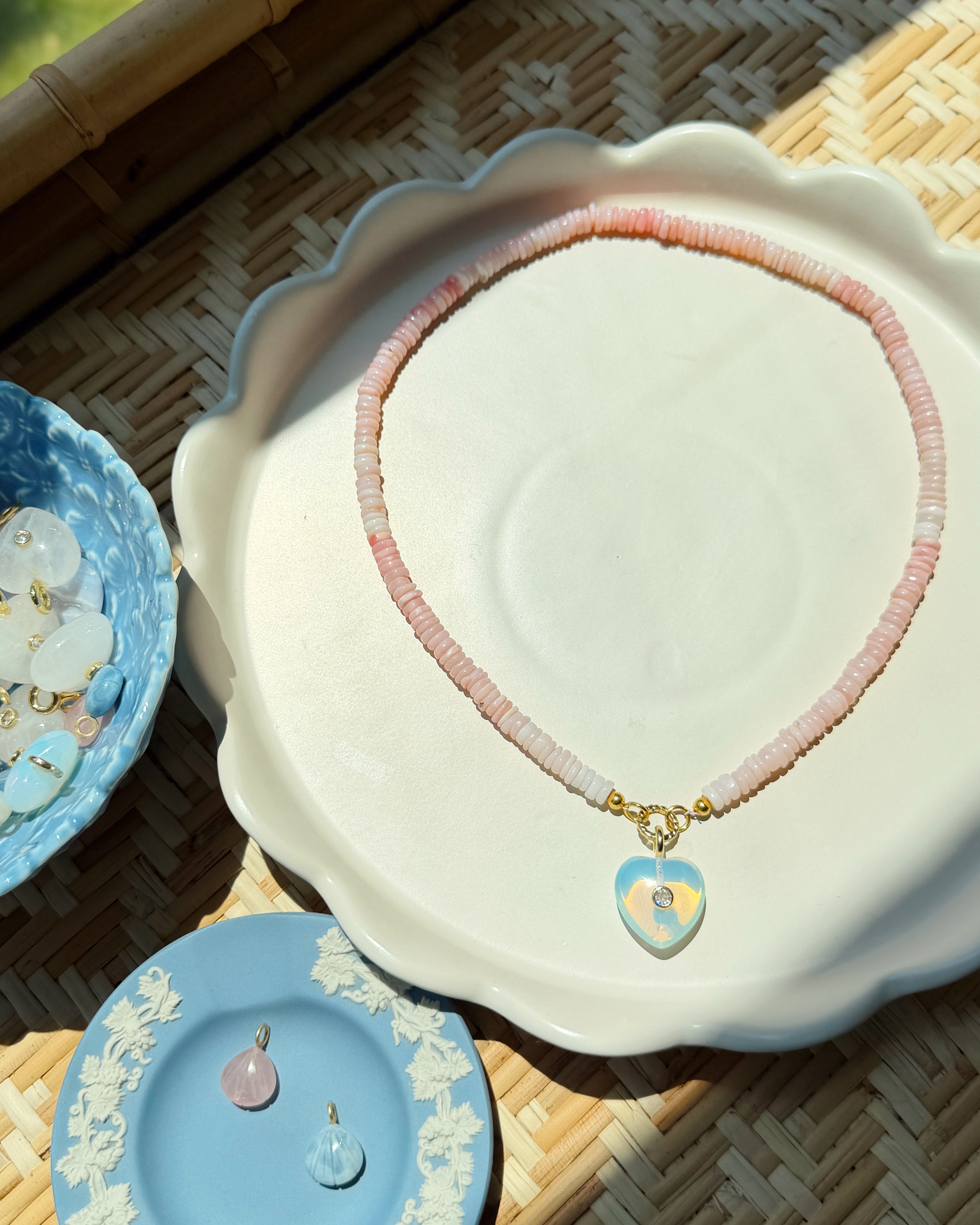 Necklace with heart-shaped pendants on a decorative dish with a woven background