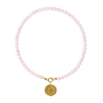 Pink beaded necklace with a gold charm on a white background