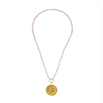 Necklace with pink beads and a gold pendant on a white background