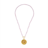 Necklace with pink beads and a gold pendant on a white background