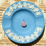 Blue decorative plate with a single pink charm