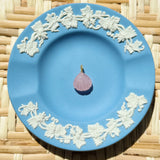 Blue decorative plate with a single pink charm