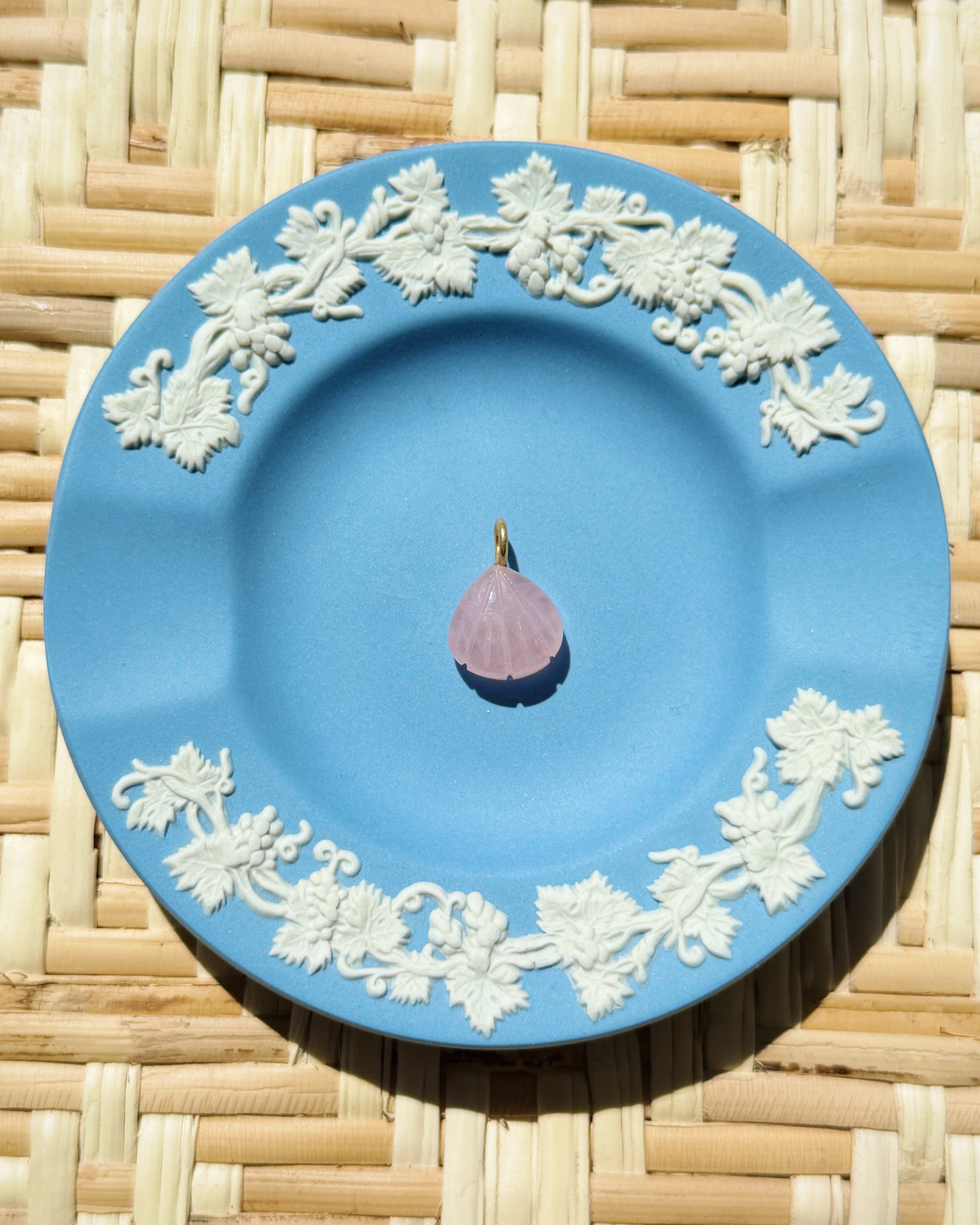 Blue decorative plate with a single pink charm