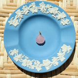 pink shell charm on a blue plate