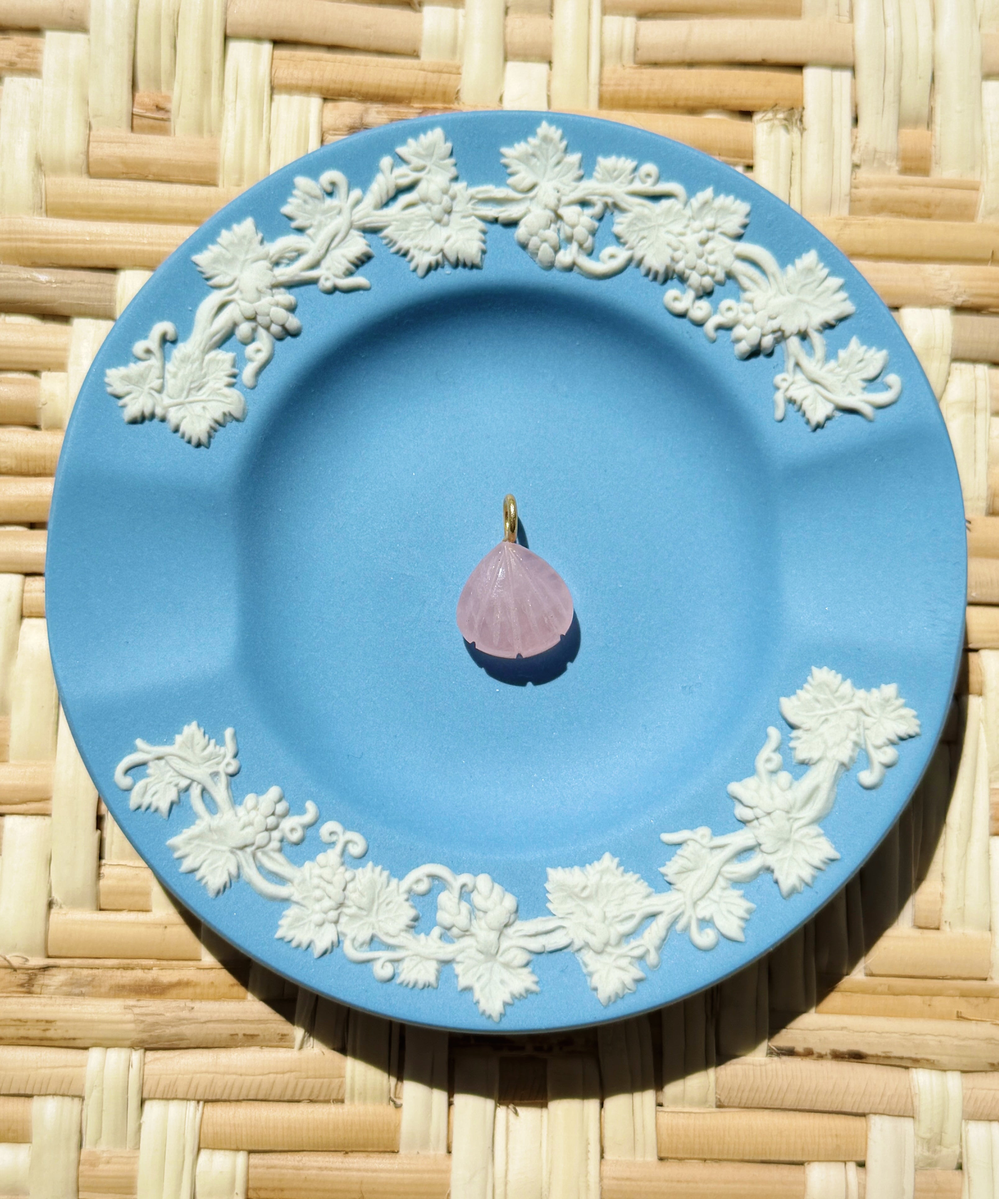 pink shell charm on a blue plate