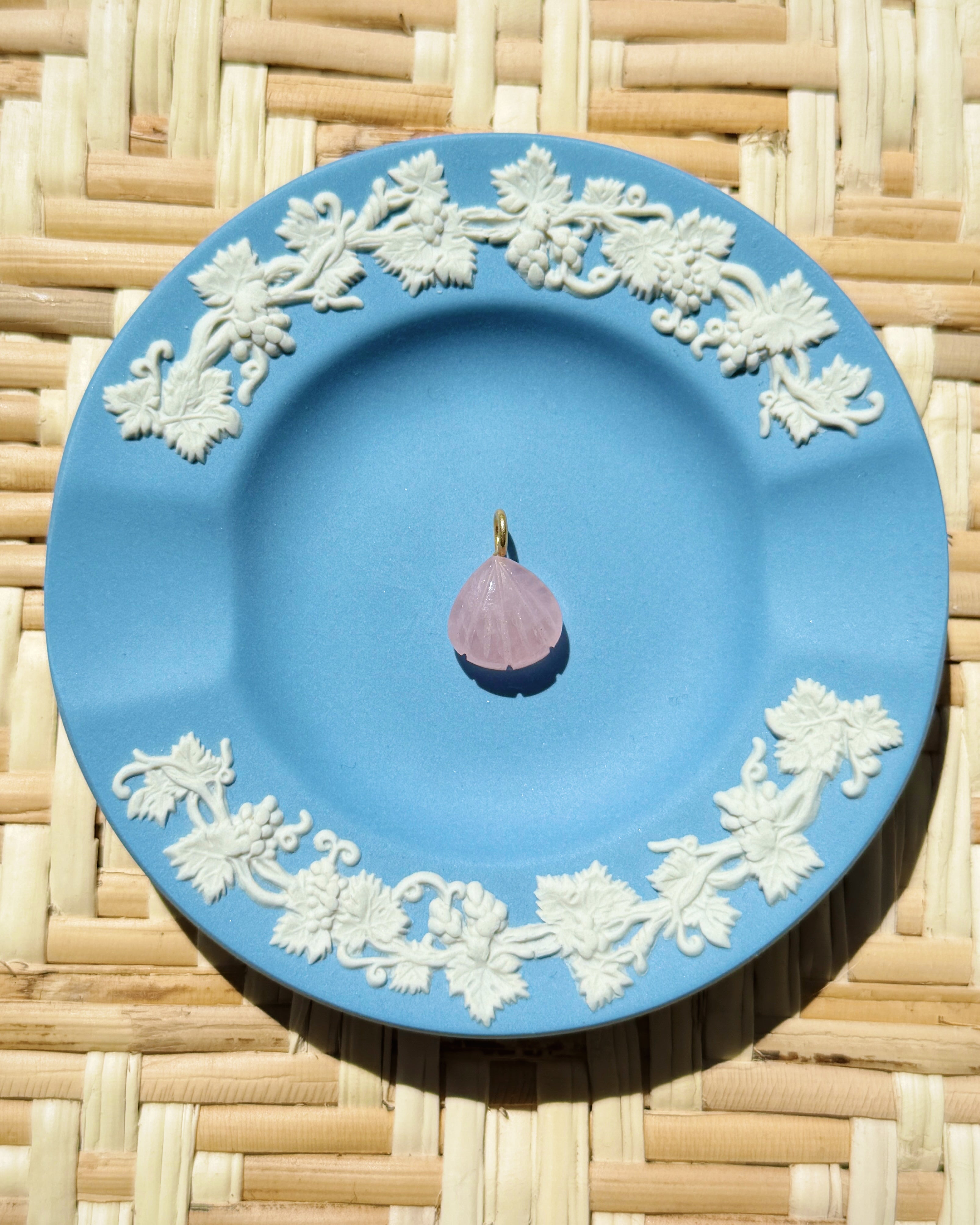 pink shell charm on a blue plate