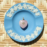 pink rose quartz heart charm on a blue plate
