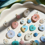 colorful stone charms on a white scalloped plate