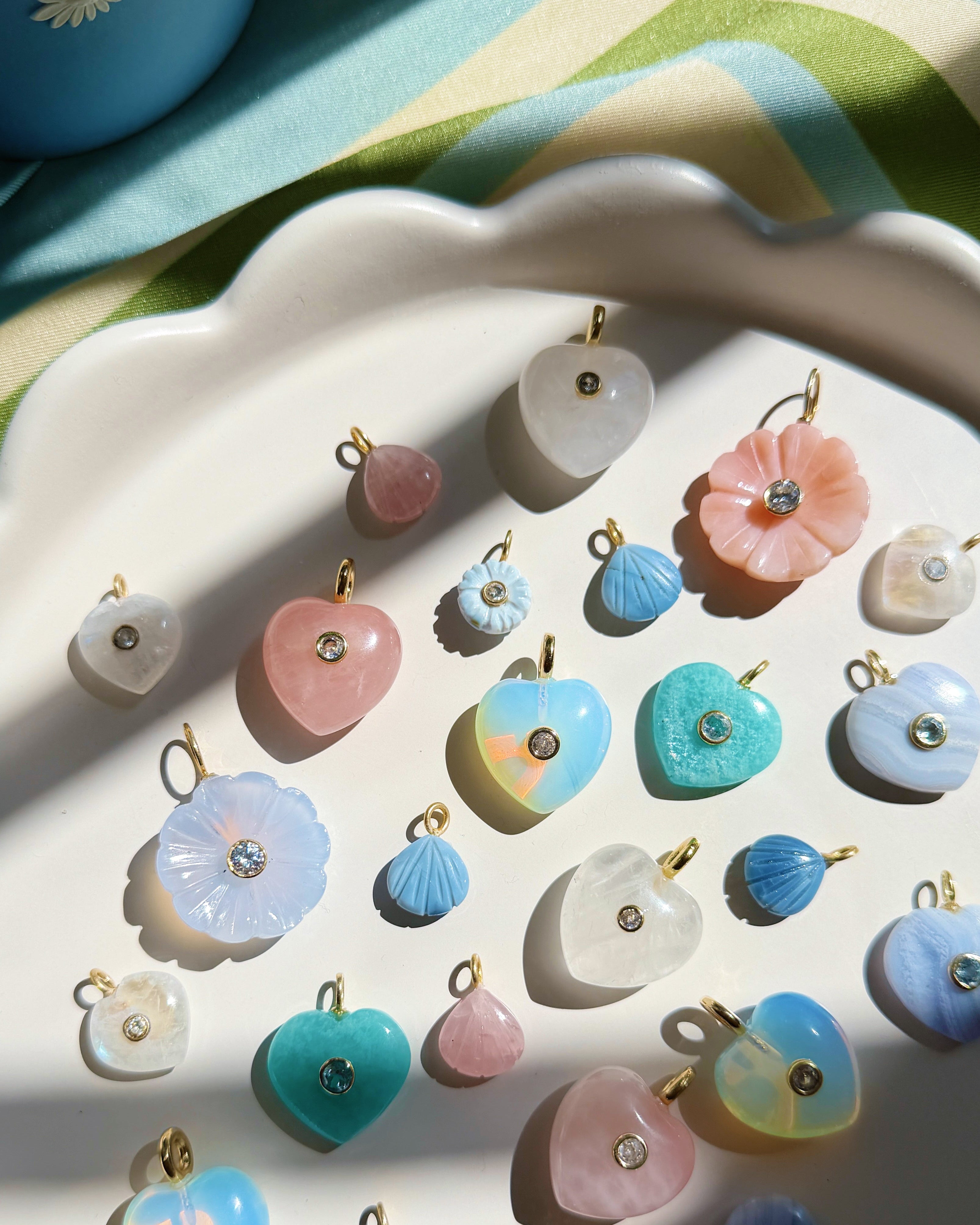 colorful stone charms on a white scalloped plate