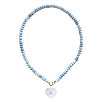 Necklace with light blue beads and a heart-shaped pendant on a white background