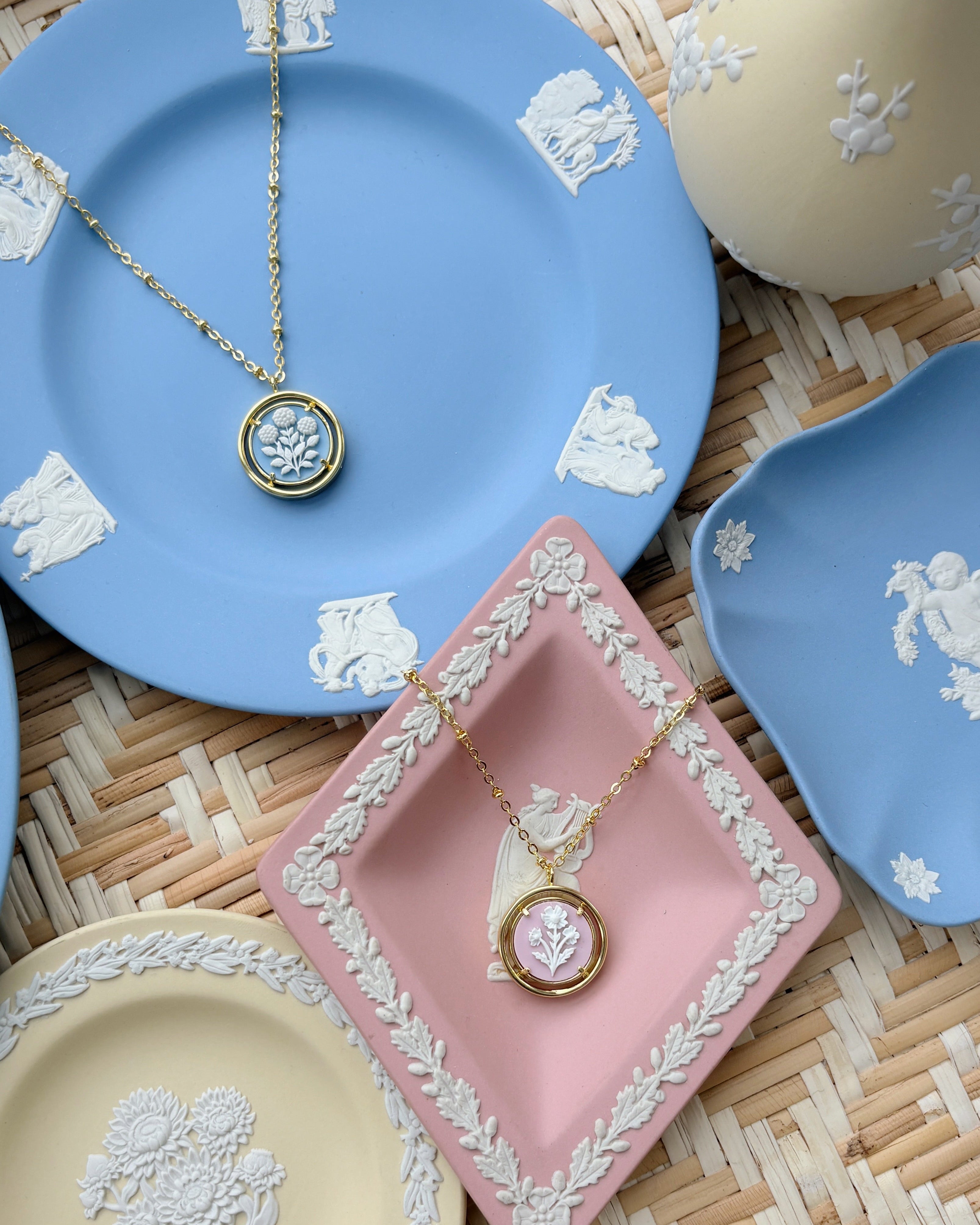 blue and pink cameo necklaces on blue and pink plates