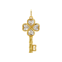 Gold key-shaped pendant with diamond-like stones on a white background
