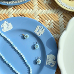 small blue floral bud charms styled on a blue plate