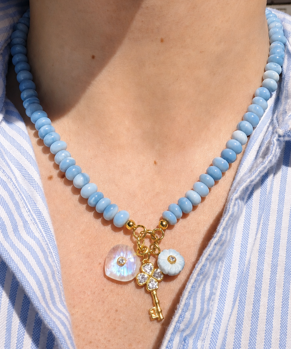 blue beaded necklace with three charms hanging