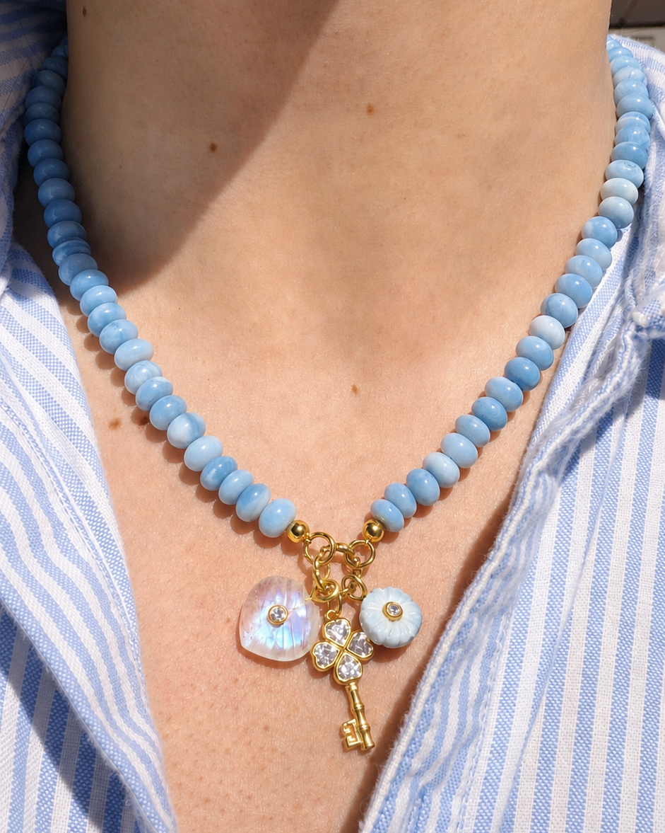 blue beaded necklace with three charms hanging