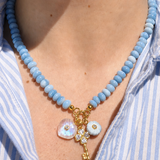 blue beaded necklace with three charms hanging