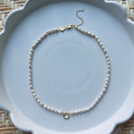 pearl strand necklace on a white plate