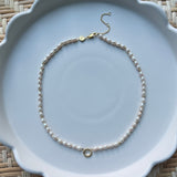 pearl strand necklace on a white plate