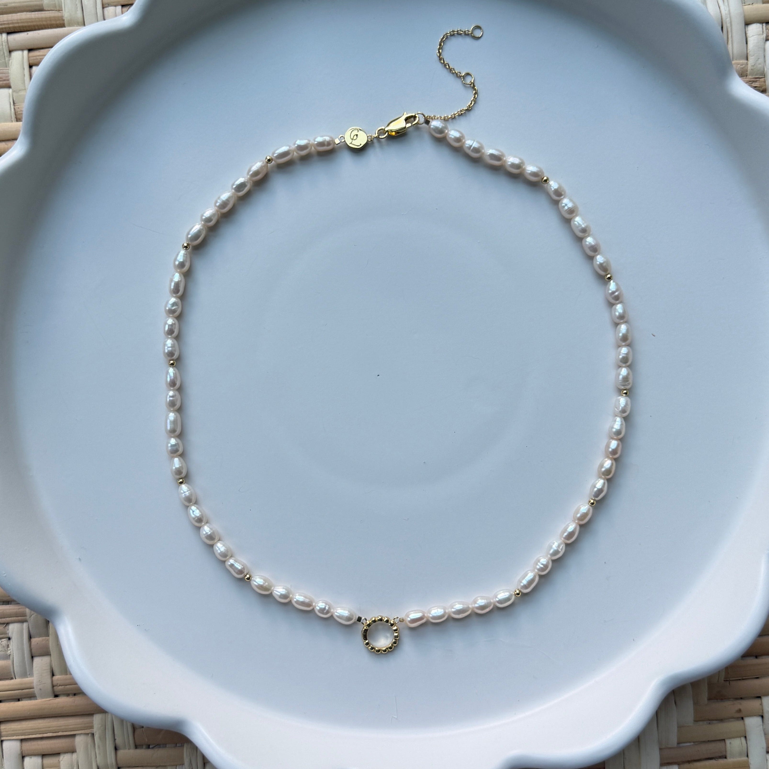 pearl strand necklace on a white plate