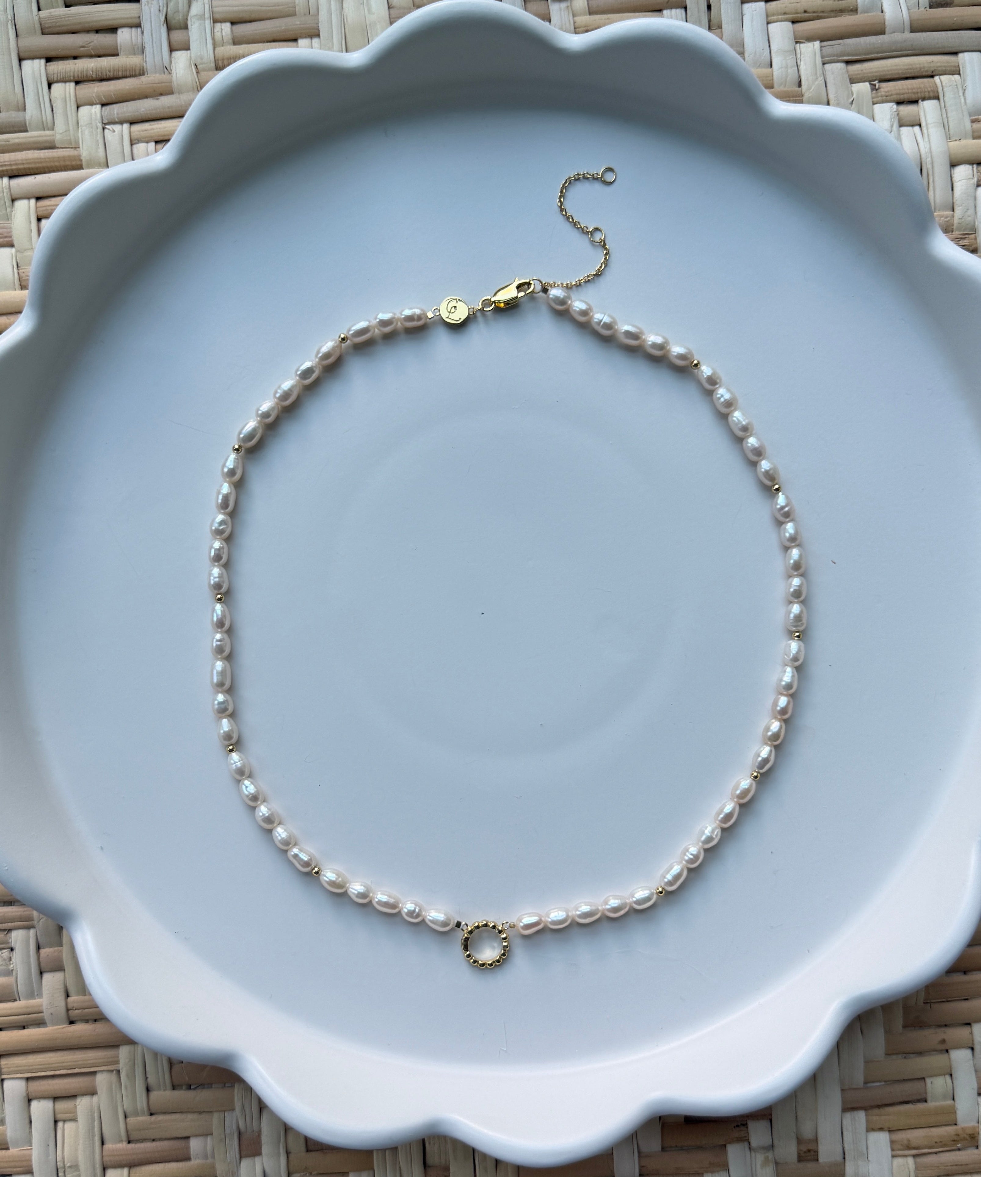pearl strand necklace on a white plate