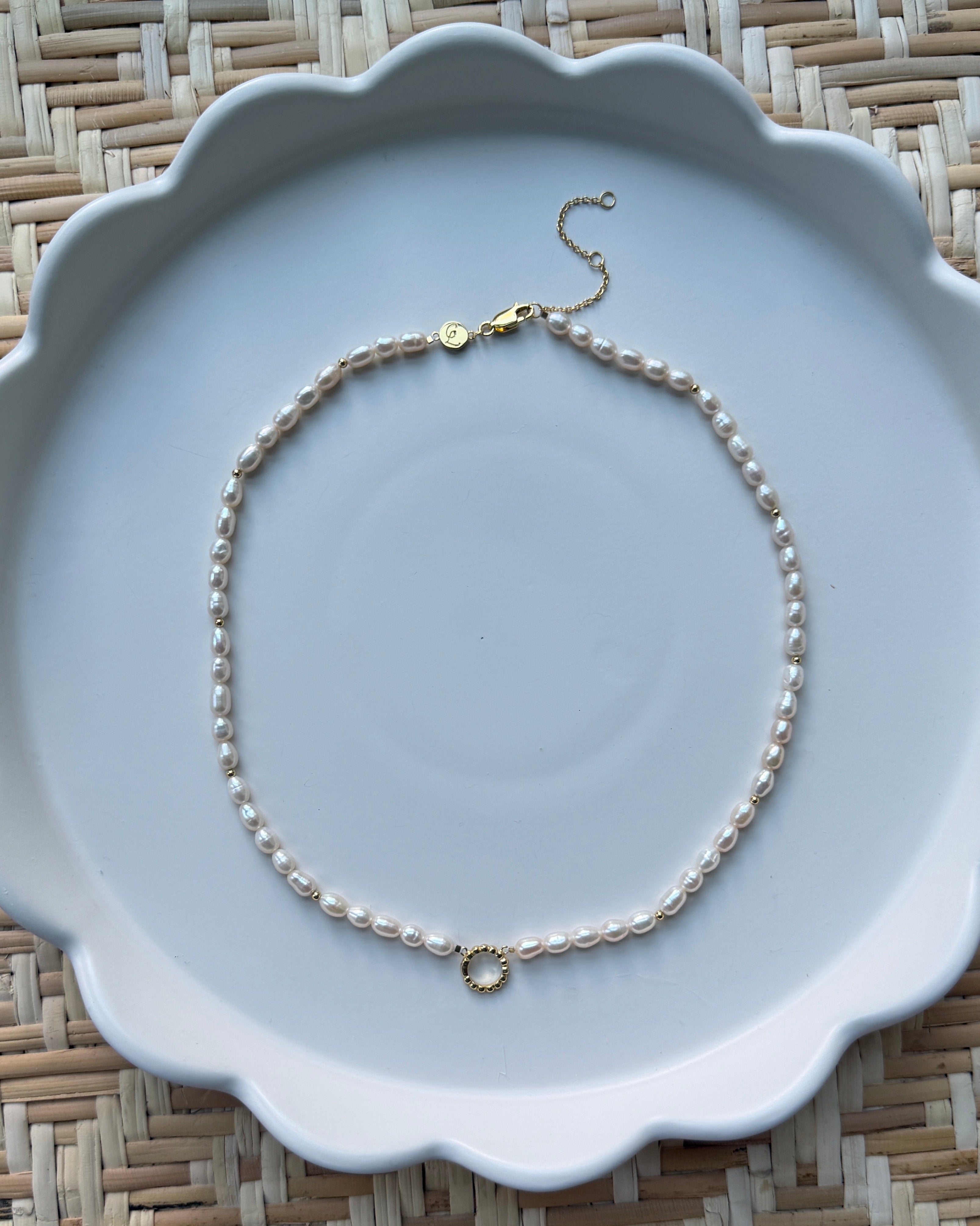 pearl strand necklace on a white plate