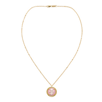 pink cameo pendant on a gold chain on white background