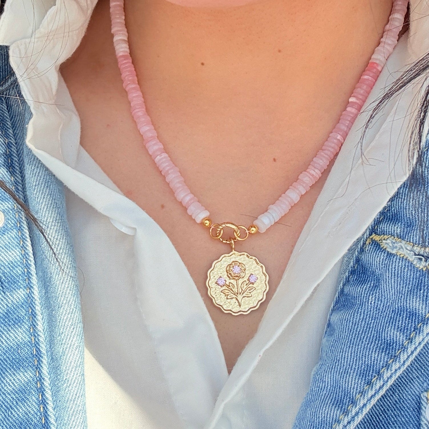 sconset rose pink beaded strand with a gold charm hanging from it on a girl wearing a white shirt