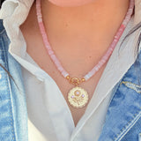sconset rose pink beaded strand with a gold charm hanging from it on a girl wearing a white shirt