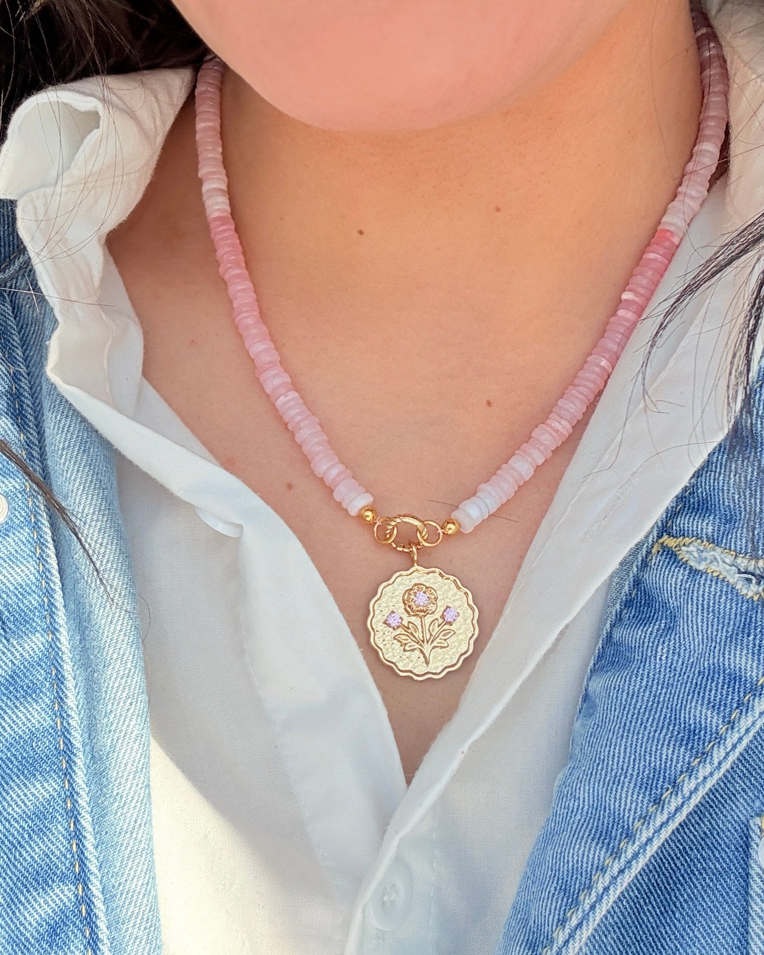 sconset rose pink beaded strand with a gold charm hanging from it on a girl wearing a white shirt