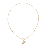 Golden necklace with a basket charm and clover charm on a white background