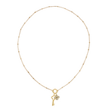 Golden necklace with a key-shaped charm and clover charm on a white background