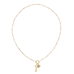Golden necklace with a key-shaped charm and clover charm on a white background